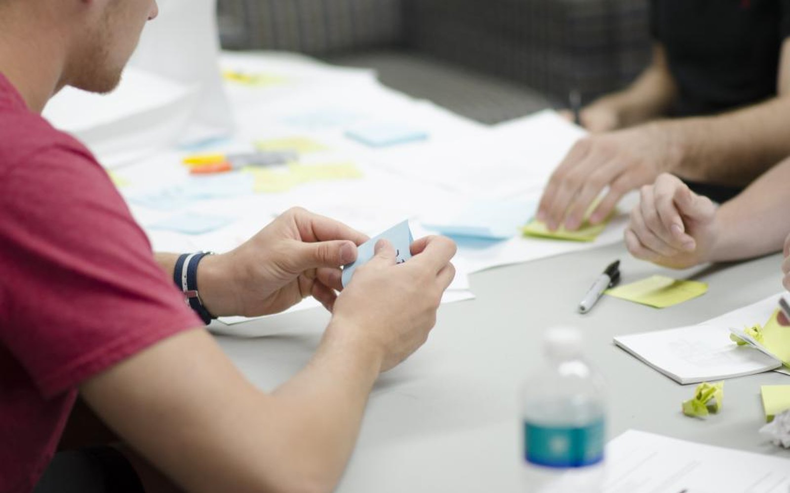 A team around a table with laptops, notes and sticky notes, working through a technical decision